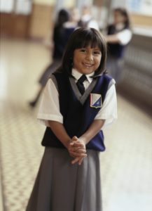 Young girl in private school uniform. Vertical composition.